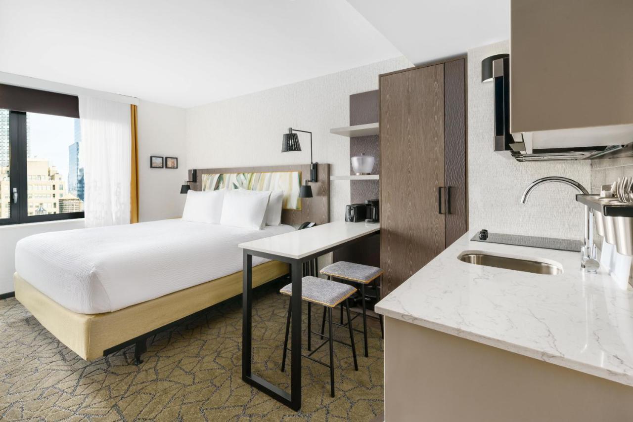 Estúdio com cama king-size, cozinha compacta completa e vista da cidade