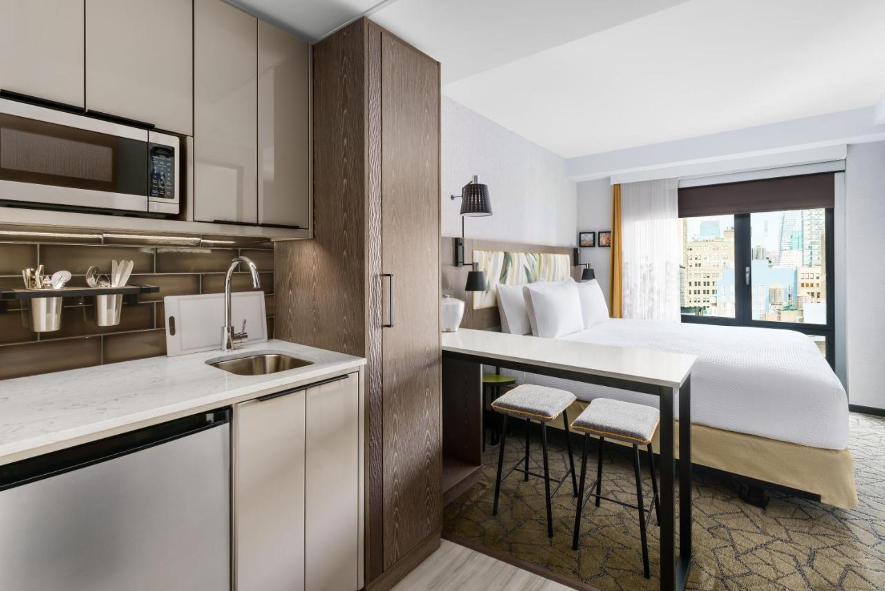 Estúdio com cama king-size, vista da cidade e cozinha compacta